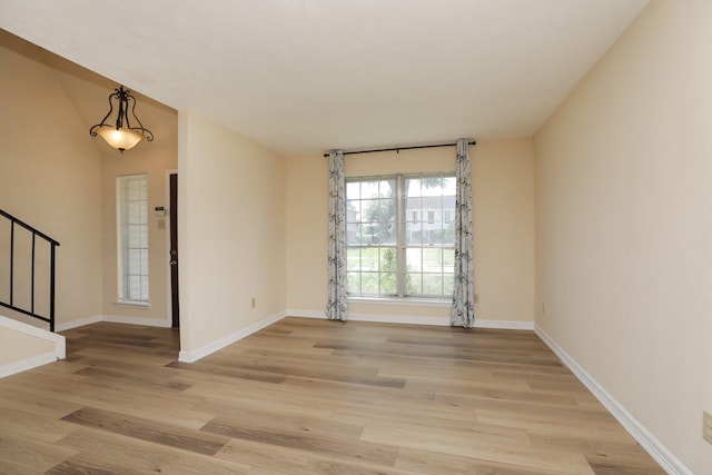 8606 Quail Vista Dr, Missouri City, TX 77489 - empty room with stairway, light wood finished floors, and baseboards