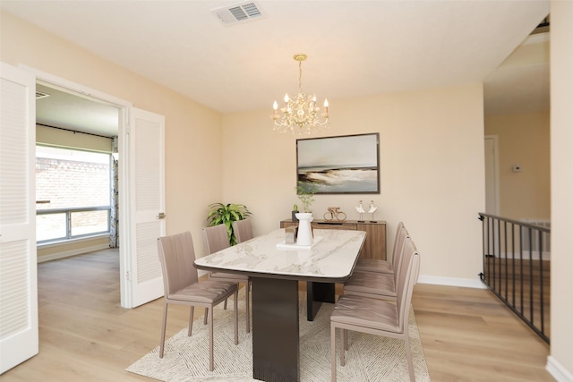 8606 Quail Vista Dr, Missouri City, TX 77489 - dining area with light wood finished floors, a chandelier, and baseboards