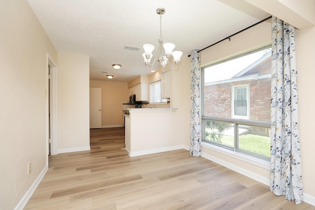 8606 Quail Vista Dr, Missouri City, TX 77489 - kitchen featuring a chandelier, light wood-style floors, white cabinetry, and plenty of natural light