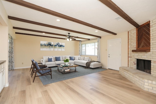 8606 Quail Vista Dr, Missouri City, TX 77489 - living room featuring a ceiling fan, a brick fireplace, beam ceiling, light wood-style flooring, and recessed lighting