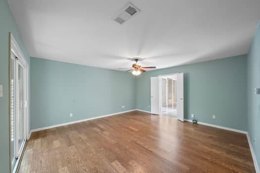 201 Vanderpool Ln Unit 118, Houston, TX 77024 - unfurnished bedroom featuring wood finished floors, baseboards, and a ceiling fan