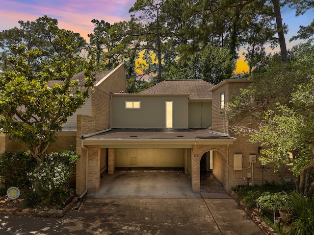 201 Vanderpool Ln Unit 118, Houston, TX 77024 - view of front of home featuring driveway, brick siding, and roof with shingles