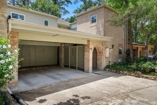 201 Vanderpool Ln Unit 118, Houston, TX 77024 - view of front of home with driveway, brick siding, and a carport
