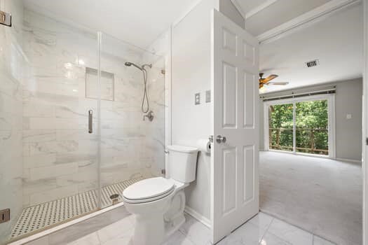 201 Vanderpool Ln Unit 118, Houston, TX 77024 - bathroom featuring marble look tiles, toilet, a marble finish shower, baseboards, and a ceiling fan
