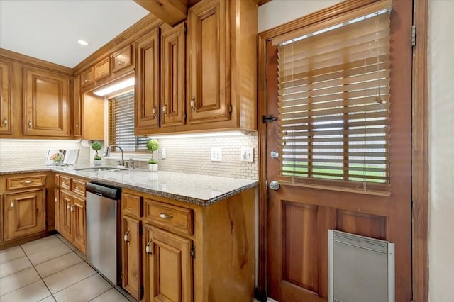 515 Canadian St, Houston, TX 77009 - kitchen with stainless steel dishwasher, a sink, backsplash, brown cabinets, and light stone counters