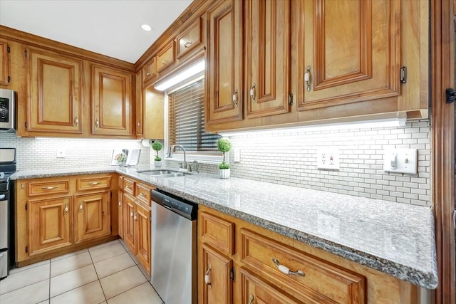 515 Canadian St, Houston, TX 77009 - kitchen with stainless steel appliances, brown cabinetry, backsplash, light stone counters, and a sink
