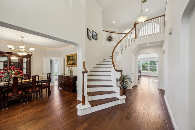 5539 Emerald Pointe Ct, Sugar Land, TX 77479 - entrance foyer featuring arched walkways, dark wood-style floors, stairs, a high ceiling, and a chandelier