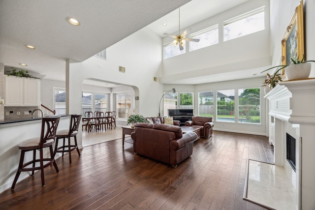 5539 Emerald Pointe Ct, Sugar Land, TX 77479 - living area with arched walkways, a fireplace, dark wood-style flooring, ceiling fan, and recessed lighting