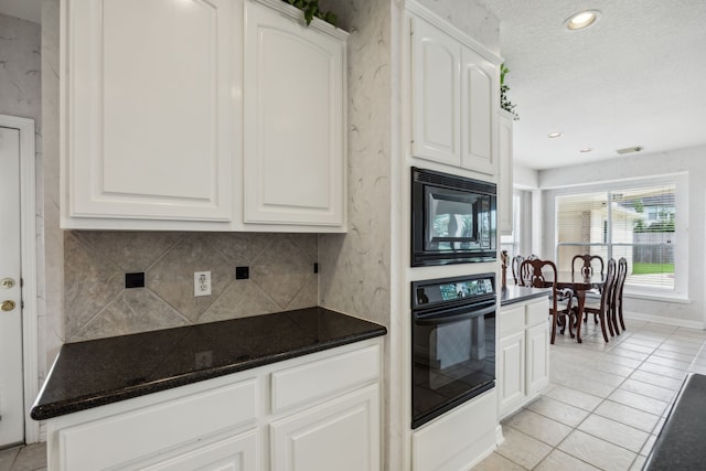 5539 Emerald Pointe Ct, Sugar Land, TX 77479 - kitchen with black appliances, backsplash, light tile patterned floors, white cabinets, and dark stone countertops