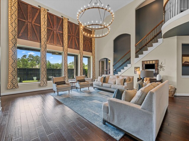 17611 Bear River Ln, Humble, TX 77346 - living area with arched walkways, a towering ceiling, stairs, dark wood finished floors, and a chandelier