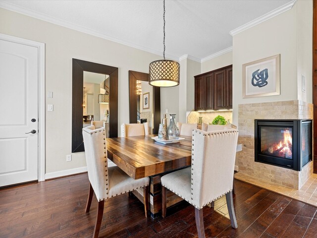 17611 Bear River Ln, Humble, TX 77346 - dining room featuring crown molding, dark wood-style flooring, a fireplace with flush hearth, and baseboards