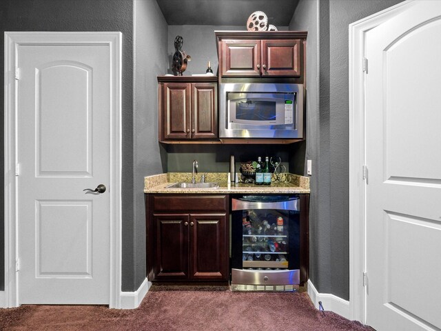 17611 Bear River Ln, Humble, TX 77346 - indoor wet bar with wine cooler, stainless steel microwave, dark carpet, a textured wall, and baseboards