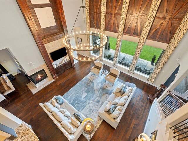 17611 Bear River Ln, Humble, TX 77346 - living room with a glass covered fireplace, a towering ceiling, a chandelier, and wood-type flooring