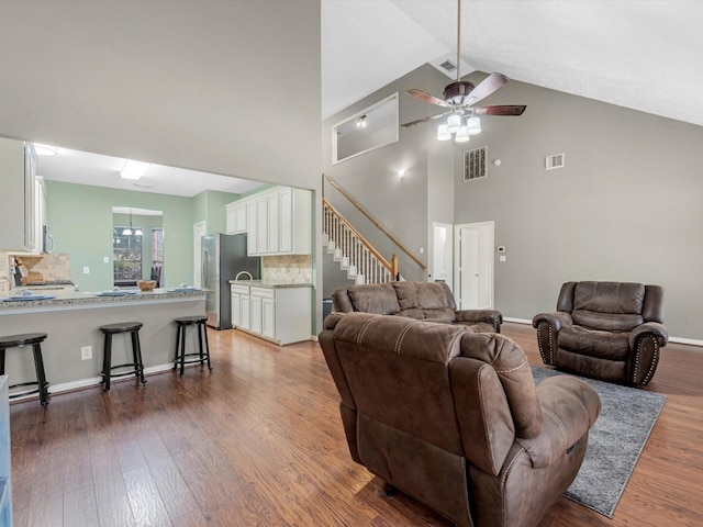 3106 Lake Breeze Ln, Crosby, TX 77532 - living room featuring wood finished floors, high vaulted ceiling, stairway, ceiling fan, and baseboards