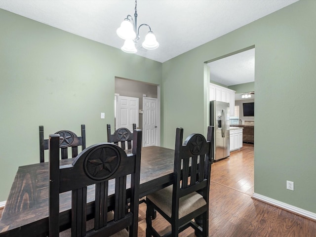 3106 Lake Breeze Ln, Crosby, TX 77532 - dining space with light wood-style flooring, a chandelier, and baseboards