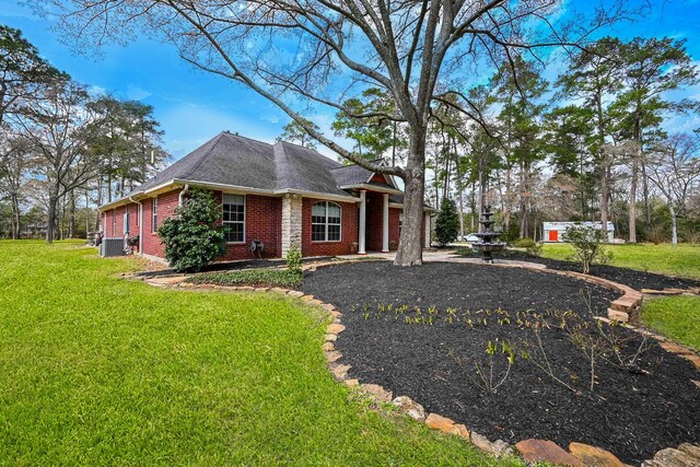 23442 Hillcrest Dr, Hockley, TX 77447 - view of home's exterior featuring brick siding, a yard, and central air condition unit