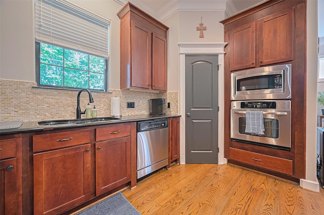 804 Enid St Unit A, Houston, TX 77009 - kitchen featuring stainless steel appliances, a sink, tasteful backsplash, light wood-type flooring, and crown molding