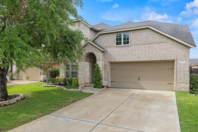 21734 Parsley Mist Ln, Richmond, TX 77469 - traditional-style house with concrete driveway, a front lawn, brick siding, a garage, and roof with shingles