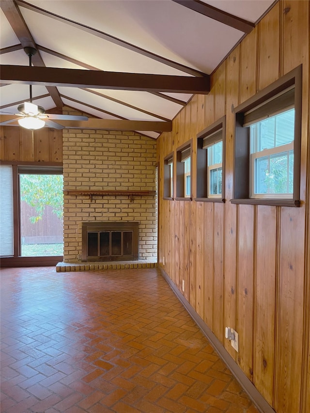 10214 Moorberry Ln, Houston, TX 77043 - unfurnished living room featuring wood walls, healthy amount of natural light, brick flooring, and a ceiling fan