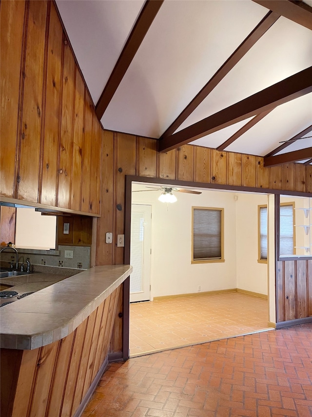 10214 Moorberry Ln, Houston, TX 77043 - kitchen featuring brown cabinets, a sink, wooden walls, brick flooring, and open floor plan