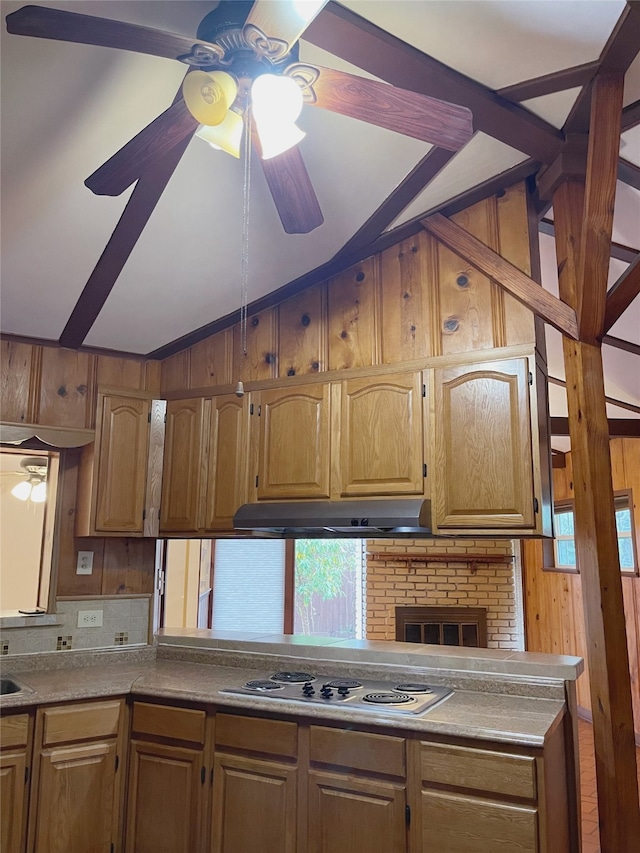 10214 Moorberry Ln, Houston, TX 77043 - kitchen with ceiling fan, lofted ceiling, stainless steel electric cooktop, under cabinet range hood, and wood walls