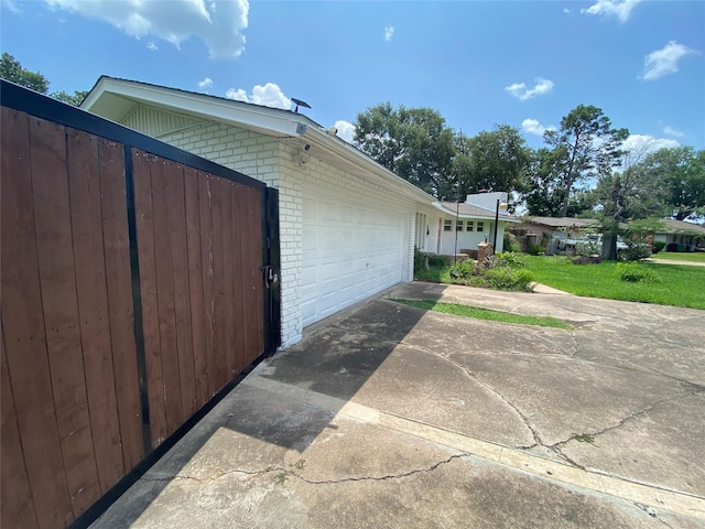 10214 Moorberry Ln, Houston, TX 77043 - view of side of property with brick siding, an attached garage, and concrete driveway