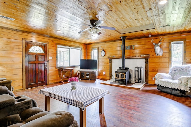 637 County Road 6502 E, Dayton, TX 77535 - living room with wood ceiling, a wood stove, wood walls, a ceiling fan, and wood finished floors