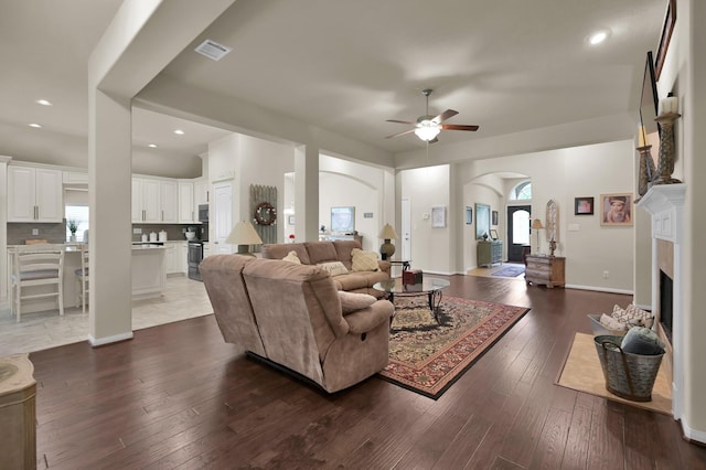 3909 Aspen Dr, Montgomery, TX 77356 - living area with arched walkways, a ceiling fan, a fireplace, dark wood-style floors, and recessed lighting