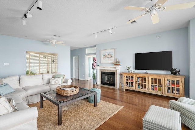 5123 W Bayshore Dr, Bacliff, TX 77518 - living room with rail lighting, ceiling fan, wood finished floors, and a tile fireplace