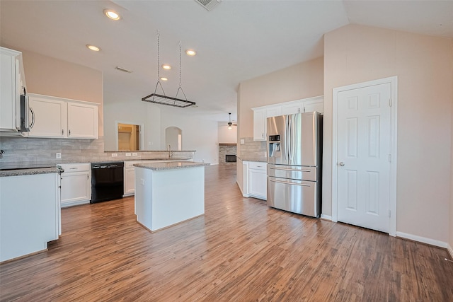 2311 Foster Leaf Ct, Richmond, TX 77406 - kitchen with stainless steel appliances, decorative backsplash, white cabinetry, vaulted ceiling, and recessed lighting