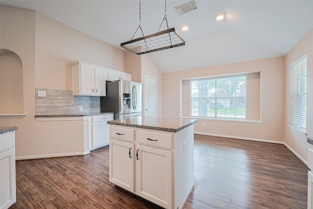 2311 Foster Leaf Ct, Richmond, TX 77406 - kitchen featuring stainless steel fridge, lofted ceiling, wood finished floors, decorative backsplash, and dark stone counters