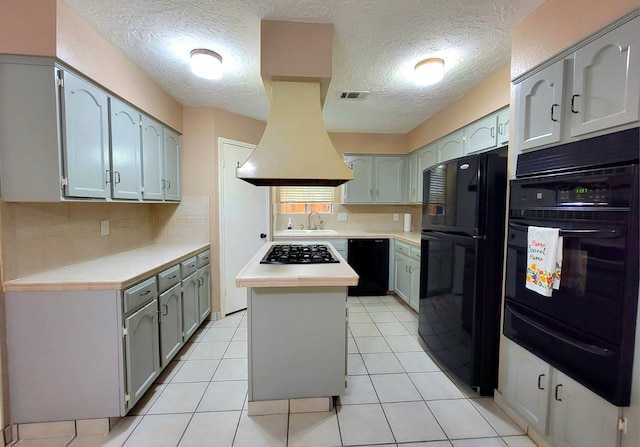 3135 Apple Dr, Missouri City, TX 77459 - kitchen featuring black appliances, a warming drawer, a kitchen island, a textured ceiling, and tasteful backsplash
