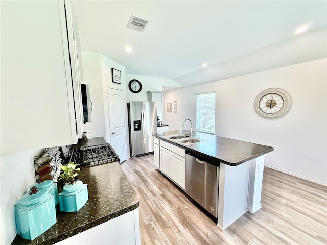 24446 Elmwood Falls Dr, Spring, TX 77373 - kitchen featuring appliances with stainless steel finishes, a sink, dark countertops, light wood-type flooring, and white cabinets