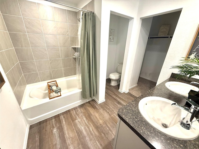 24446 Elmwood Falls Dr, Spring, TX 77373 - full bathroom featuring wood finished floors, shower / tub combo, toilet, double vanity, and baseboards