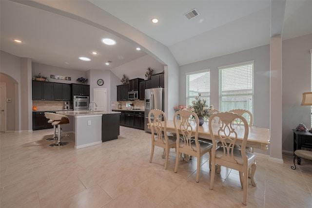 8107 Bosphorus St, Houston, TX 77044 - dining room with arched walkways, vaulted ceiling, recessed lighting, and light tile patterned floors