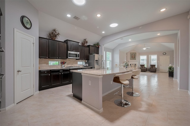 8107 Bosphorus St, Houston, TX 77044 - kitchen with appliances with stainless steel finishes, vaulted ceiling, a ceiling fan, backsplash, and open floor plan