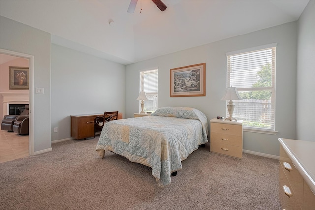 8107 Bosphorus St, Houston, TX 77044 - bedroom with light carpet, ceiling fan, baseboards, a glass covered fireplace, and lofted ceiling