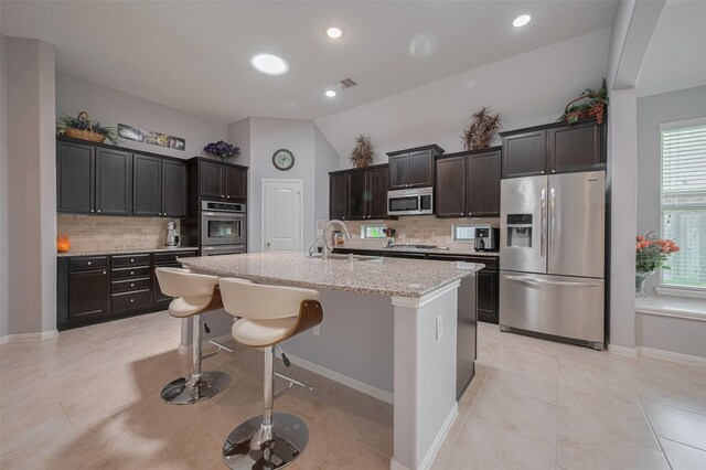 8107 Bosphorus St, Houston, TX 77044 - kitchen with stainless steel appliances, a sink, backsplash, light stone counters, and vaulted ceiling