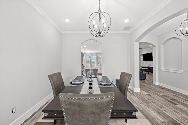 1420 Palomino Trl, Angleton, TX 77515 - dining space featuring a chandelier, arched walkways, crown molding, baseboards, and wood finished floors
