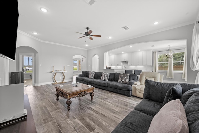 1420 Palomino Trl, Angleton, TX 77515 - living area featuring arched walkways, ceiling fan, plenty of natural light, ornamental molding, and recessed lighting