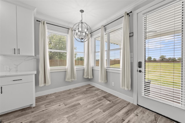 1420 Palomino Trl, Angleton, TX 77515 - unfurnished dining area featuring a chandelier, crown molding, baseboards, and light wood finished floors