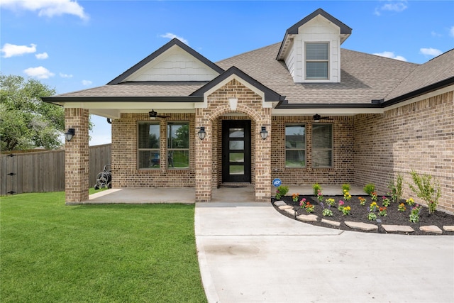 1420 Palomino Trl, Angleton, TX 77515 - view of exterior entry featuring brick siding, a patio area, a shingled roof, and ceiling fan