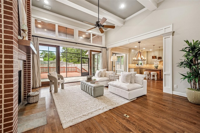 5311 Indigo St, Houston, TX 77096 - living room with a brick fireplace, beam ceiling, dark wood-style flooring, plenty of natural light, and a ceiling fan