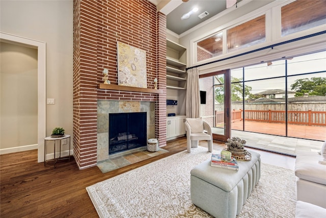 5311 Indigo St, Houston, TX 77096 - living area with a high ceiling, a fireplace, wood finished floors, and built in shelves