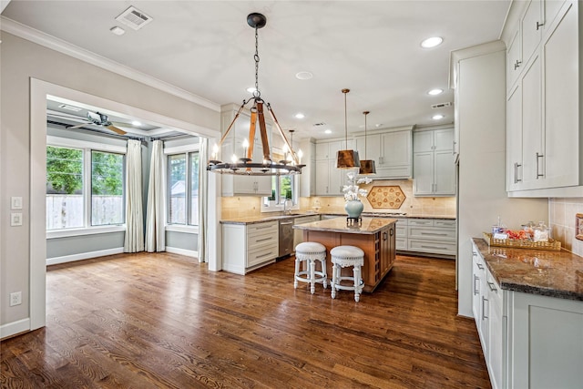 5311 Indigo St, Houston, TX 77096 - kitchen featuring dishwasher, a center island, ornamental molding, backsplash, and stone countertops