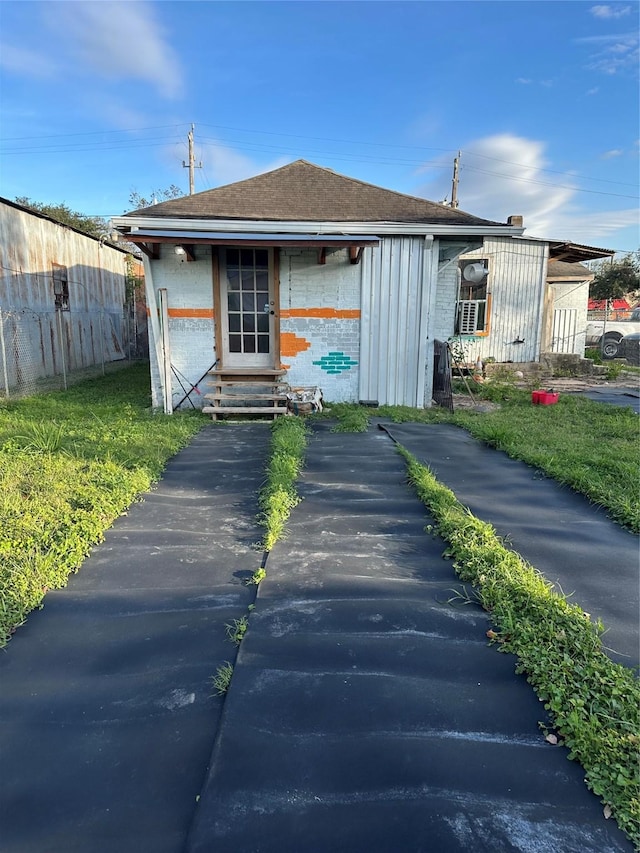 304 Lockwood Dr, Houston, TX 77011 - back of property featuring brick siding, entry steps, and a shingled roof