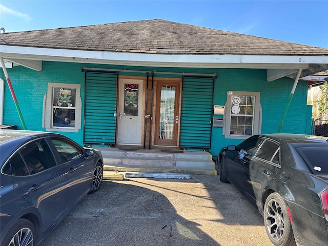 304 Lockwood Dr, Houston, TX 77011 - view of front of property with brick siding, a shingled roof, and a porch