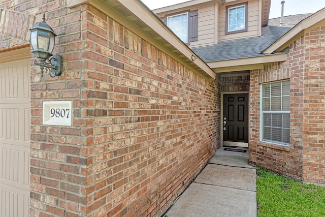 9807 Opal Rock Dr, Rosharon, TX 77583 - doorway to property featuring a shingled roof and brick siding