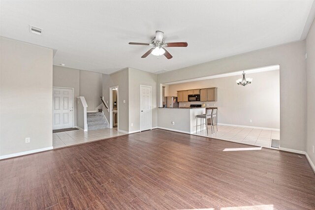 9807 Opal Rock Dr, Rosharon, TX 77583 - unfurnished living room with ceiling fan, light wood-style flooring, a chandelier, and stairs