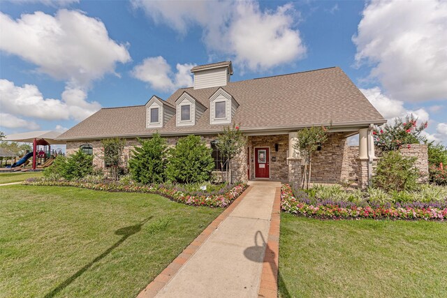 9807 Opal Rock Dr, Rosharon, TX 77583 - new england style home featuring a front lawn, a shingled roof, and a playground